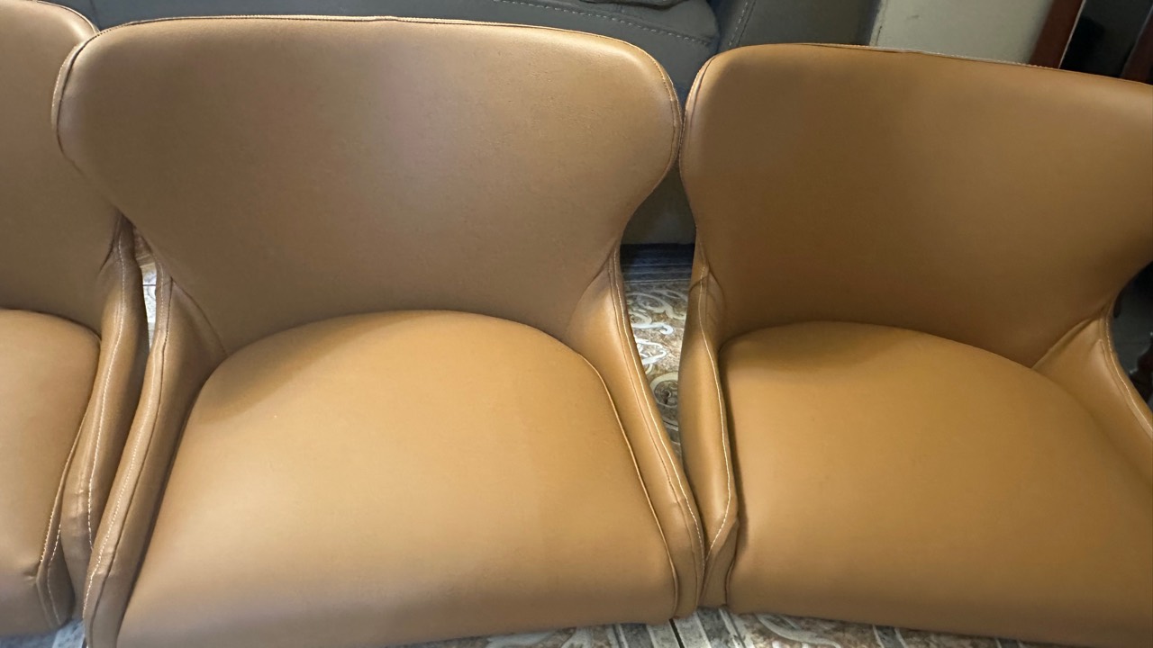 Two tan upholstered chair shells shown side by side
